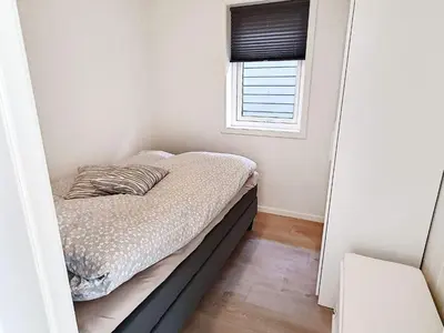 a small bedroom with a bed and a window at 6 person holiday home in VATNE in Vatne