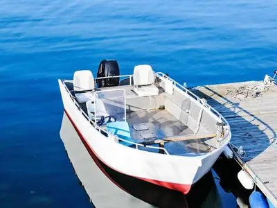 a boat is docked at a dock in the water at 8 person holiday home in VATNE in Vatne