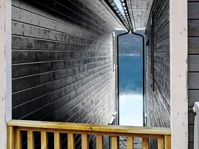 a window on the side of a building with a bench at 8 person holiday home in VATNE in Vatne