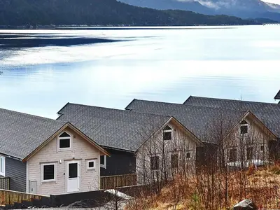 a row of houses next to a body of water at 8 person holiday home in VATNE in Vatne