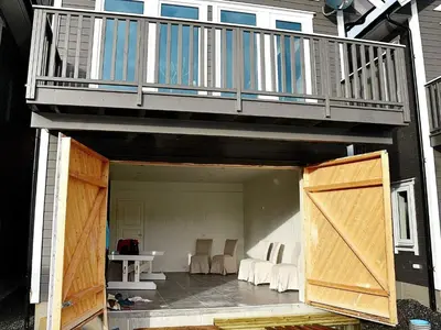 an open patio with a balcony and a wooden door at 8 person holiday home in VATNE in Vatne