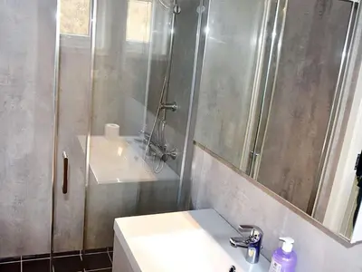 a bathroom with a sink and a shower with a mirror at 8 person holiday home in VATNE in Vatne
