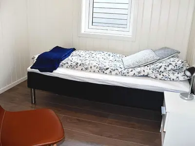 a bed with two books on it in a room at 8 person holiday home in VATNE in Vatne
