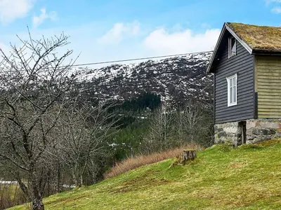 a house on a hill with a snow covered mountain at Secluded Mountain Retreat-By Traum in Vassenden