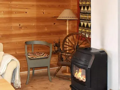 a living room with a stove and a chair at Secluded Mountain Retreat-By Traum in Vassenden