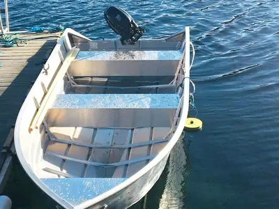 a white boat sitting on the water next to a dock at 7 person holiday home in KLOKKARVIK in Klokkarvik