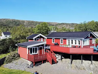 a couple of red houses sitting on top of a hill at 7 person holiday home in KLOKKARVIK in Klokkarvik