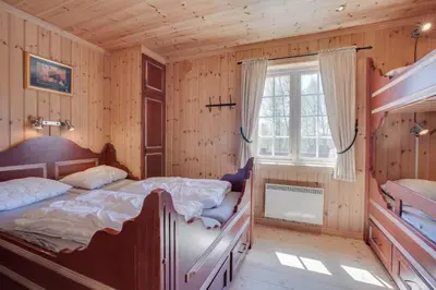 a bedroom with a bed in a wooden room at Mugnablikk in Beitostøl