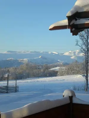 a view of a snow covered field with mountains at Mugnablikk in Beitostøl
