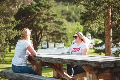 two women sitting at a picnic table at Toftemo Turiststasjon in Dovre