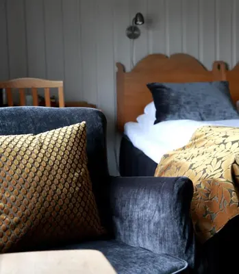 a bedroom with a bed and a couch and a chair at Sanner Hotell in Gran