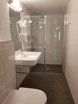 a bathroom with a toilet and a sink and a shower at Sanner Hotell in Gran