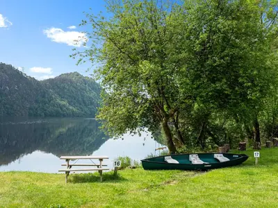 a boat sitting next to a bench next to a lake at Grimen Camping in Bergen