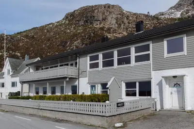 a house with a mountain in the background at Havly Bed & Breakfast in Hauge