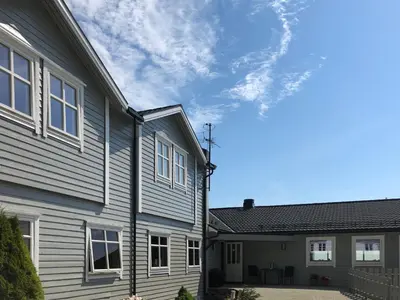 a gray house with white windows on the side of it at Havly Bed & Breakfast in Hauge