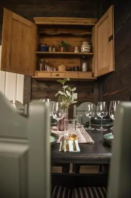 a wooden table with wine glasses on it at Fjelleventyret gårdsovernatting in Skjåk
