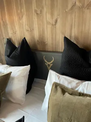 a bedroom with black and white pillows on a bed at Fjelleventyret gårdsovernatting in Skjåk