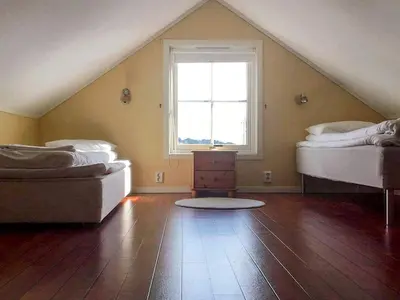 a attic room with two beds and a window at 6 person holiday home in Austrheim in Utkeila