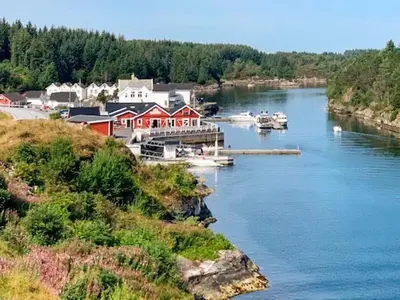 a river with boats docked in a small town at 6 person holiday home in Austrheim in Utkeila