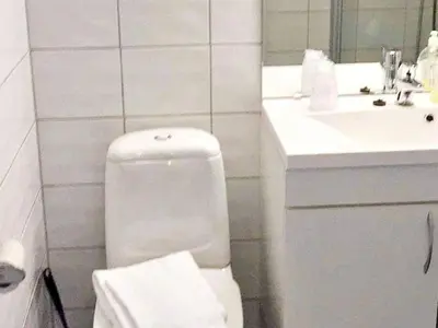 a white bathroom with a toilet and a sink at 6 person holiday home in Austrheim in Utkeila