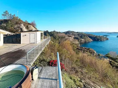 a balcony of a house with a view of the water at 12 person holiday home in Fitjar in Fitjar