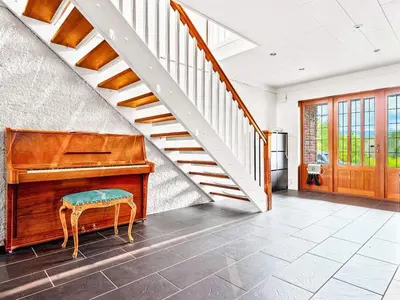 a piano in a living room with a staircase at 12 person holiday home in Fitjar in Fitjar