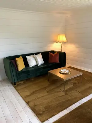a living room with a green couch and a coffee table at Tunold Gård - Freden in Stryn