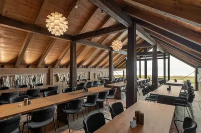 a dining room with wooden ceilings and tables and chairs at Øyna Kulturlandskapshotell in Straumen