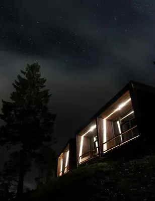 a house lit up at night with a starry sky at Øyna Kulturlandskapshotell in Straumen