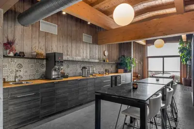 a kitchen with wooden walls and a table and chairs at Øyna Kulturlandskapshotell in Straumen