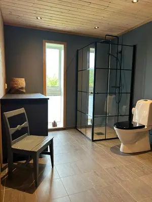 a bathroom with a toilet and a chair and a mirror at Tuddal Hyttegrend HYTTA KÅNS in Tuddal