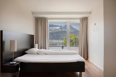 a bedroom with a bed with a view of a mountain at Aursnes Hotell in Sykkylven