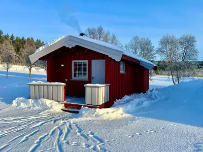 a red house with snow on the roof in the snow at Harekroken in Tynset