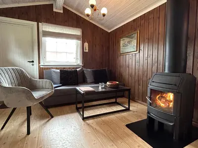 a living room with a couch and a stove at Harekroken in Tynset