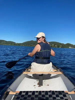 a woman in a boat with a paddle in the water at Unik fjøsleilighet in Levanger