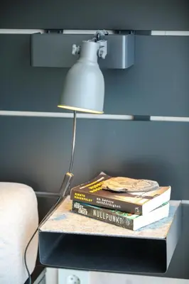 a stack of books sitting on a table with a lamp at Hardanger Fjordtun PANORAMA cabin near the Hardangerfjord with fantastic fjordview, silence and nature in Herand