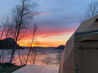a view of a lake at sunset from a camper at FUGELVÅGEN, cabins and glamping in Ålvundfjord