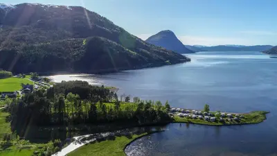 an island in the middle of a body of water at FUGELVÅGEN, cabins and glamping in Ålvundfjord
