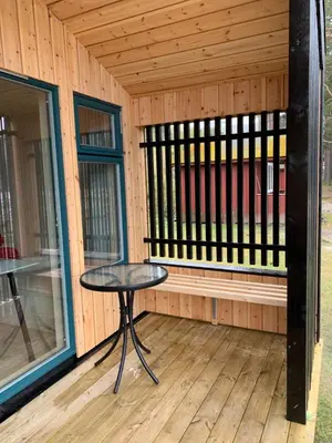 a small table on the porch of a wooden cabin at FUGELVÅGEN, cabins and glamping in Ålvundfjord