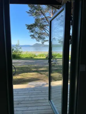 an open door with a view of the ocean at FUGELVÅGEN, cabins and glamping in Ålvundfjord
