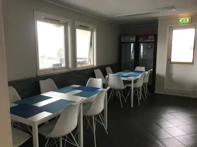 a dining room with blue and white tables and chairs at EIDE Gjestehus in Eide