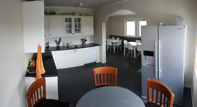 a kitchen with a refrigerator and a table and chairs at EIDE Gjestehus in Eide