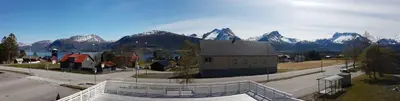 a large building with mountains in the background at EIDE Gjestehus in Eide