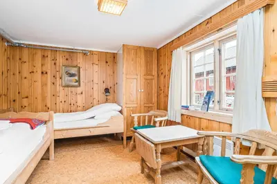 a bedroom with two beds and a table and chairs at Kongsvold Fjeldstue by Frich`s in Oppdal