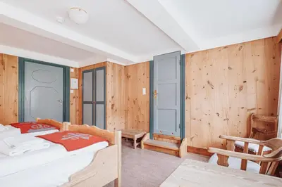 a bedroom with a bed and wooden walls at Kongsvold Fjeldstue by Frich`s in Oppdal