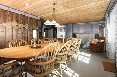 a dining room with a wooden table and chairs at Korsholmen - by Classic Norway Hotels in Karvåg