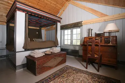 a bedroom with a bed and a dresser and a mirror at Korsholmen - by Classic Norway Hotels in Karvåg