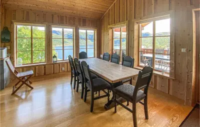 a dining room with a wooden table and chairs at Stordalen in Bjordal