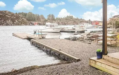 a group of boats docked at a dock on the water at Amazing Apartment In Fjell in Lokøy