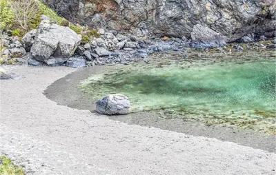 a rock in the middle of a body of water at Amazing Apartment In Fjell in Lokøy